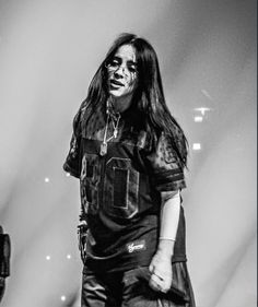 a man with long hair standing in front of a microphone