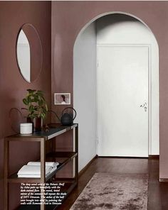 the hallway is painted pink and has a rug on the floor with an arch in it