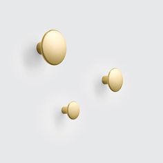 three brass knobs on a white background