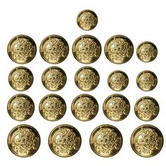 twelve brass buttons with intricate designs on them