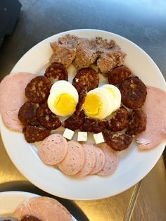 a plate with meat, eggs and sausages on it