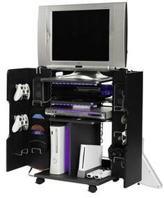 an entertainment center with a tv, video game console and gaming accessories on wheels in front of it