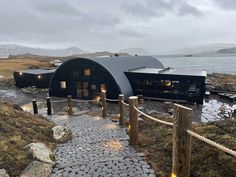 a house on the side of a mountain with a walkway leading up to it's entrance