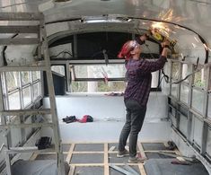 a man is working on the inside of an old bus with tools in his hands