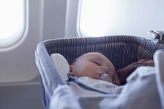 a baby is sleeping in a basket on an airplane