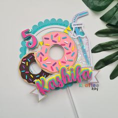 a birthday cake topper with a donut and sprinkles on it