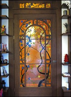 a wooden door with stained glass in the center and shelves on either side that have bookshelves