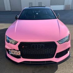 a pink car parked in front of a building