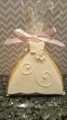 a cookie shaped like a wedding dress on top of a counter next to a bag