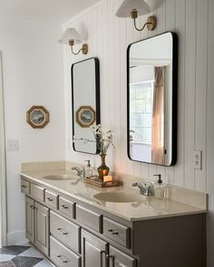 a bathroom with two sinks and mirrors on the wall