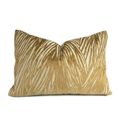 a gold and white zebra print pillow on a white background