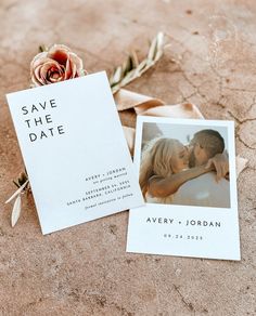 save the date cards are laying next to a flower