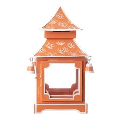 an orange and white bird house with two bells on it's roof, sitting in front of a white background