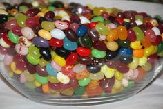 a bowl filled with jelly beans sitting on top of a table