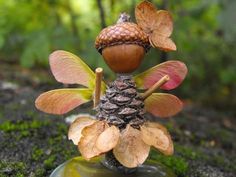 a figurine made out of pine cones and acorns on top of moss