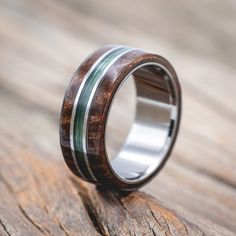 a wooden ring with green stripes on it