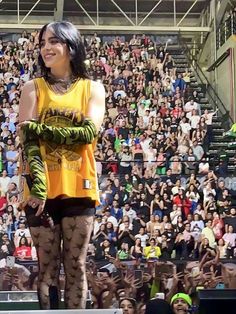 a woman standing on top of a stage in front of a large group of people