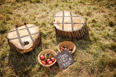 two baskets filled with fruit sitting on top of a grass covered field