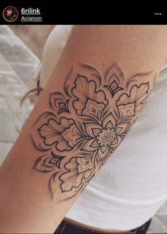 a woman's arm with a flower tattoo design on the left side of her arm