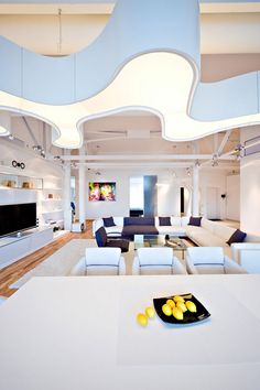 a living room filled with furniture and a flat screen tv on top of a white table