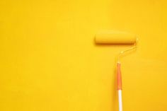 a yellow wall with a red and white toothbrush next to it