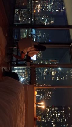 a bedroom with a view of the city at night