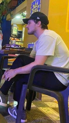 a man sitting on top of a chair in front of a laptop computer next to a water bottle