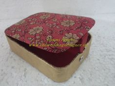 an open red and gold box with flowers on it