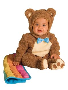 a baby in a bear costume sitting on a blanket