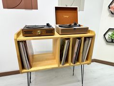 a record player sitting on top of a wooden shelf