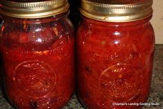 two jars filled with red liquid sitting on top of a counter