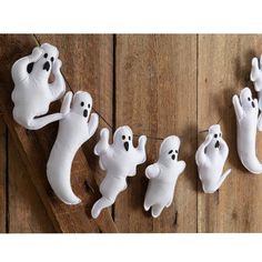 halloween decorations made to look like ghostes hanging from clothes line on wooden planks