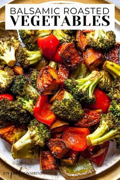 a white plate topped with broccoli and red bell peppers next to a fork