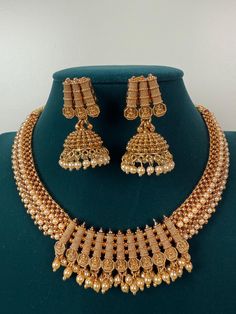 This exquisite piece of craftsmanship comes from our Traditional collection. Finish: 24 grams gold finish Necklace Fastening: Adjustable Dori  Perfect for Indian weddings. Earring jhumka Fastening: Push Back Contains: 1 necklace, 1 pair of earrings Luxury Gold Temple Necklace With Peacock Design, Luxury Temple Necklace With Peacock Design For Festivals, Ornate Gold Plated Necklaces For Wedding, Ornate Gold Plated Necklace For Wedding, Gold Plated Necklaces With Latkans For Festivals, Gold Plated Latkans Necklaces For Festivals, Festival Gold-plated Necklaces With Latkans, Gold Plated Chandbali Necklaces For Ceremonial Occasions, Gold Plated Chandbali Necklaces For Ceremonies