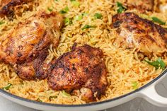 chicken and rice in a skillet with green onions on the side, ready to be eaten