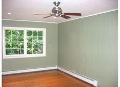 an empty room with a ceiling fan and window