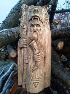 a wooden carving of an old man with a microphone in his hand, on top of a tree