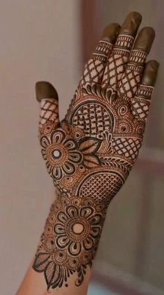 a woman's hand with henna tattoos on it