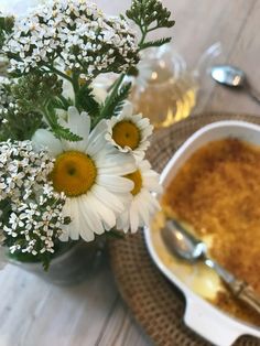 a bowl of soup and some flowers on a table