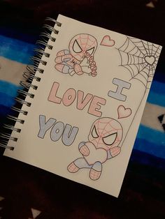 a notebook with spiderman and i love you written on the front in black ink