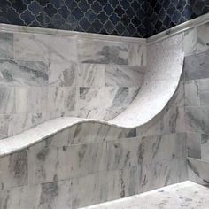 a bathroom with marble tile walls and flooring in the shape of a curved wave