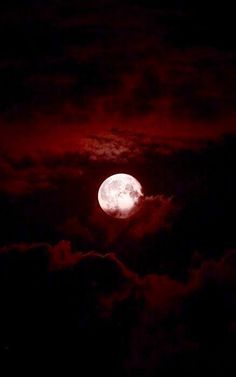 the full moon is seen through clouds in this dark night time sky with red hues