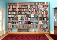 a bookshelf filled with lots of different kinds of records and cds on top of it