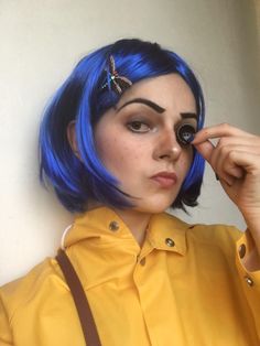 a woman with blue hair wearing a yellow shirt