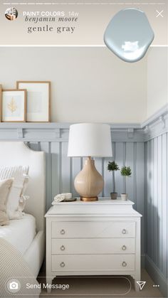 a white dresser sitting next to a bed in a bedroom