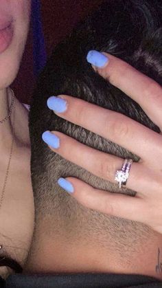 a man and woman with blue nail polish holding each other