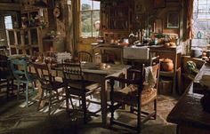 an old fashioned kitchen and dining room with lots of furniture in the middle of it