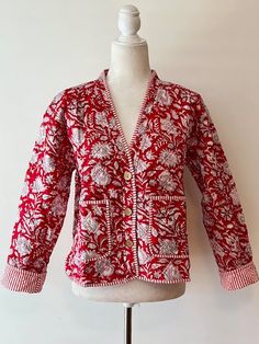 Indian Handmade Women's Quilt Jacket With Stripe Piping Looks Rich. Featuring a V-Neck button down, and two front pockets. Hand block printed in a vibrant red and white floral print. The contrast piping is a stand out. Beautiful. Styled in a short blazer jacket resting just below the waist. Long sleeves, fold back to expose the mixed print and piping, adjusting the sleeve length. This jacket should work well with your existing wardrobe. Great over skirts, crop pants, long pants, and even shorts. Short Blazer, Womens Quilted Jacket, How To Look Rich, Quilt Jacket, Contrast Piping, Blazer And Shorts, Crop Pants, Red Jacket, Cotton Quilts