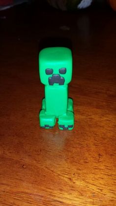 a green toy sitting on top of a wooden table