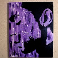 a painting on the wall of a man's face with purple and black colors